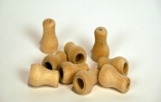 Custom wooden tassels with counter-bored holes for cord pass-through, available in bulk for large-scale production.